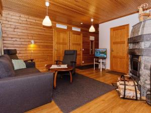 a living room with a couch and a fireplace at Holiday Home Kulta-käkönen 10 by bomba by Interhome in Nurmes