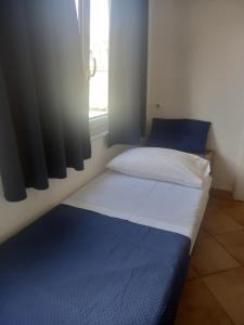 a bedroom with a bed with a blue blanket and a window at 99 Scalini in Naples