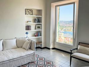 a living room with a couch and a large window at Apartment Mareviglia - Meereswunder by Interhome in Imperia +22 photos