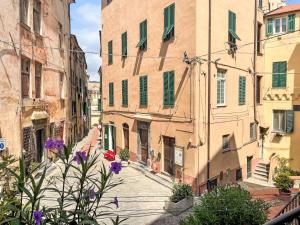 an alley in an old town with purple flowers at Apartment Mareviglia - Meereswunder by Interhome in Imperia