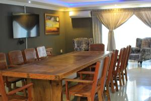 路易特里哈特President Guest Lodge的配有木桌椅的餐厅