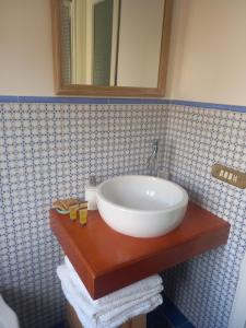 a bathroom sink with a white bowl on a wooden counter at 99 Scalini in Naples