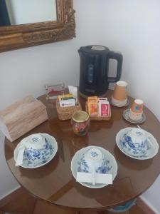 a table with four plates and a coffee maker at 99 Scalini in Naples