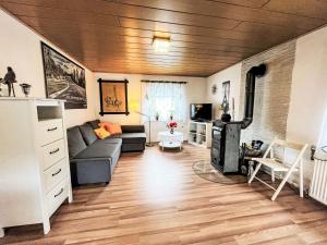 a living room with a couch and a stove at Holiday Home Ferienhaus Renata nahe Nürburgring by Interhome in Quiddelbach