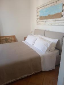 a bedroom with a bed with white sheets and pillows at 99 Scalini in Naples