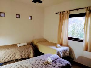 a room with two twin beds and a window at Luna Jatun in Purmamarca