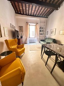 a living room with yellow chairs and a table at Il cuore in Toscana in Massa Marittima