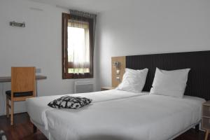 Postelja oz. postelje v sobi nastanitve Hôtel Bagatelle Paris Nord Roissy CDG