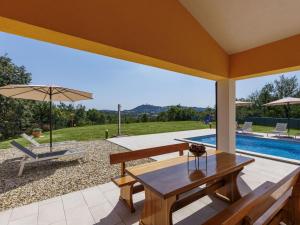a patio with a table and an umbrella and a pool at Holiday Home Villa Ana Lucija by Interhome in Labin