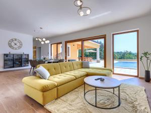 a living room with a yellow couch and a table at Holiday Home Villa Ana Lucija by Interhome in Labin