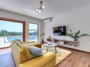 a living room with a yellow couch and a tv at Holiday Home Villa Ana Lucija by Interhome in Labin