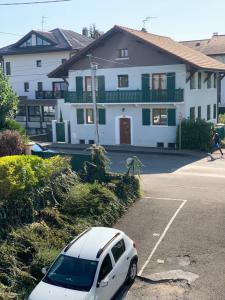 a white car parked in a parking lot in front of a house at FLEUR De LYS - PROCHE CENTRE VILLE ET LAC in Thonon-les-Bains +5 photos