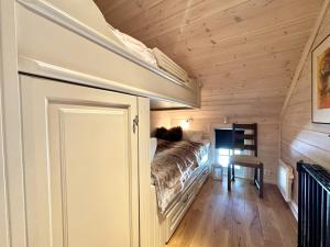 a bedroom with a bed in a wooden room at Cozy Ski-In Ski-Out Apartment on Geilo, Stunning Views! in Geilo