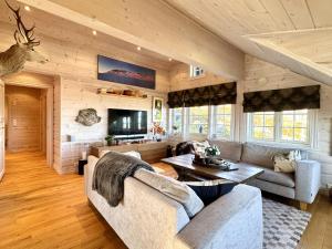 a living room with a couch and a table at Cozy Ski-In Ski-Out Apartment on Geilo, Stunning Views! in Geilo