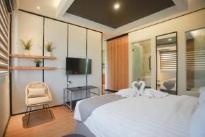 a bedroom with a bed and a chair and a television at Allstay Ecotel Yogyakarta in Yogyakarta