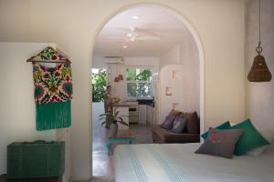 a bedroom with a bed and a living room at LiveTulum in Tulum