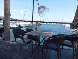 ein Tisch und Stühle auf einer Terrasse in der Nähe des Wassers in der Unterkunft belles chambres toutes équipées bord de mer gérance nouvelle in San-Nicolao + 1 Foto
