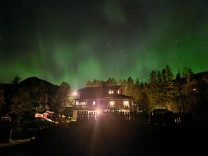 a house with the aurora in the sky at Holiday Riverside Beach Camping in Gol +19 photos