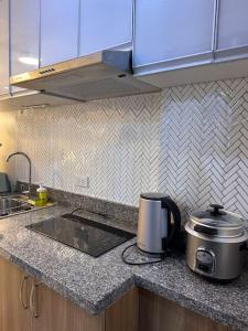 a kitchen with a counter top with a slow cooker at Haiya's Staycation Aesthetic & Cozy in Tagaytay in Biluso