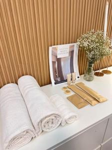 a white counter with towels and a vase of flowers at Haiya's Staycation Aesthetic & Cozy in Tagaytay in Biluso