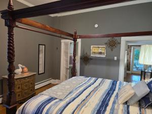 a bedroom with a large bed with a wooden frame at Newly Renovated Historic 6-Bedroom Manor, Where Timeless Elegance Meets Modern Luxury in Onancock