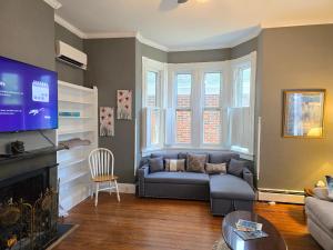 a living room with a couch and a tv at Newly Renovated Historic 6-Bedroom Manor, Where Timeless Elegance Meets Modern Luxury in Onancock +73 photos