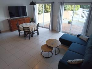a living room with a blue couch and a table at Angenehmes Haus in Perros-Guirec