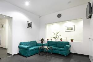 a living room with a blue couch and a table at My Hotel Apollon in Prague