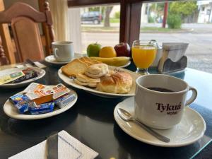 a table with a cup of coffee and plates of food at Hotel Tykua in Gualeguaychú
