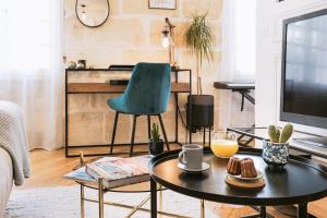 ein Wohnzimmer mit einem Couchtisch und einem TV in der Unterkunft Magnifique Appartement pour 2 en Centre-Ville in Bordeaux