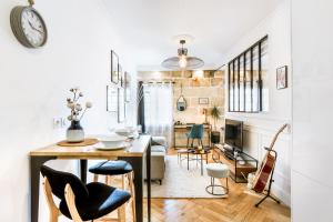 eine Küche und ein Wohnzimmer mit Tisch und Stühlen in der Unterkunft Magnifique Appartement pour 2 en Centre-Ville in Bordeaux