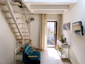 a living room with a blue chair and stairs at La Casa di Ginevra in Lamezia Terme