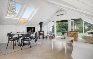 a living room with a table and chairs and a fireplace at 4 Bedroom Stunning Home In Tisvildeleje in Tisvildeleje