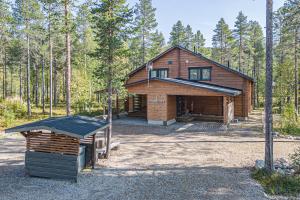 a log cabin in the woods with a grill in front at Levillas koutakaari 6B in Levi