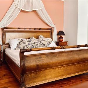sypialnia z drewnianym łóżkiem z baldachimem w obiekcie Resort Maják w mieście Horní Soběšovice