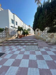 una strada vuota con un muro di pietra e un edificio di Neruka House a Torremolinos Altre 5 foto