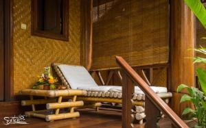 a porch with a rocking chair on a house at Santai Hotel in Amed