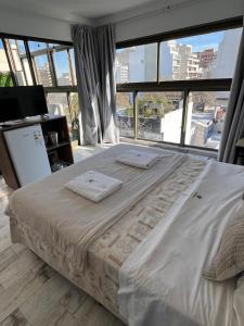 a large bed in a room with a large window at XV Apartamentos in La Plata
