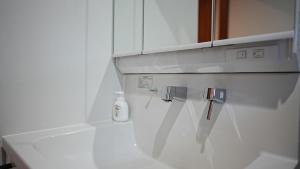 ŌdōriにあるHOTELHOUSE Nekogoya Hachiken 八軒の白いキッチン(白いキャビネット、シンク付)