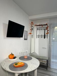 a living room with a table and a tv at Студия in Karagandy +12 photos