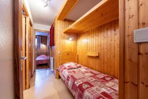 a bedroom with a bed in a wooden wall at La Bévéria in Pralognan-la-Vanoise