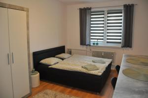 a small bedroom with a bed and a window at Apartmán Mičinská in Banská Bystrica