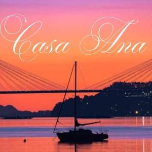 una barca a vela in acqua al tramonto con un ponte di Casa Ana a Redondela