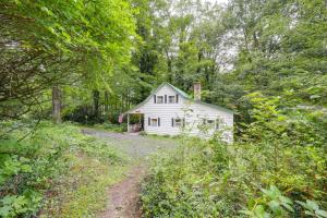 une maison blanche au milieu d'une forêt dans l'établissement 17 Mi to Sugar Mountain Tensies Cottage, à Linville Falls