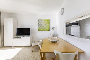 Una sala de estar blanca con una mesa de madera y un televisor. en A&N Nevada 76, en Torre del Mar