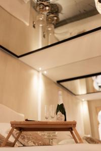 una mesa con dos copas y una botella de vino en Love room Dubaï & Balnéo, en Saint-Rambert-d'Albon