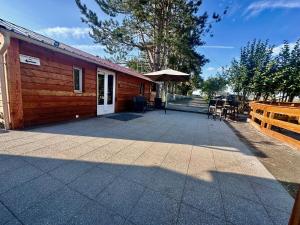 Domek z patio, stołem i krzesłami w obiekcie Le Bold'air Terrain Agricole Loisir Cross Étang w mieście Boncourt