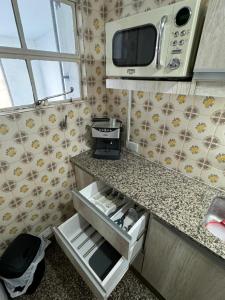 a kitchen with a counter with a microwave above it at Departamento en junin in Junín +13 photos