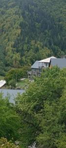 a house sitting on top of a hill next to a river at Guest House pesvebi in Mestia