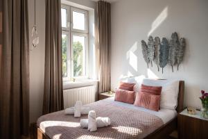 Un dormitorio con una cama con dos animales de peluche encima. en Amazing apartament in the heart of Kazimierz, en Cracovia